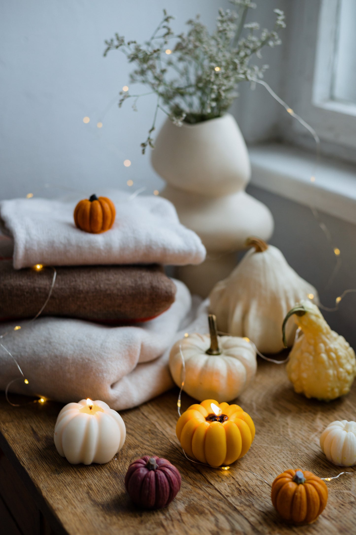 Autumn pumpkin candle on wooden table—Thanksgiving and Halloween decorative accent