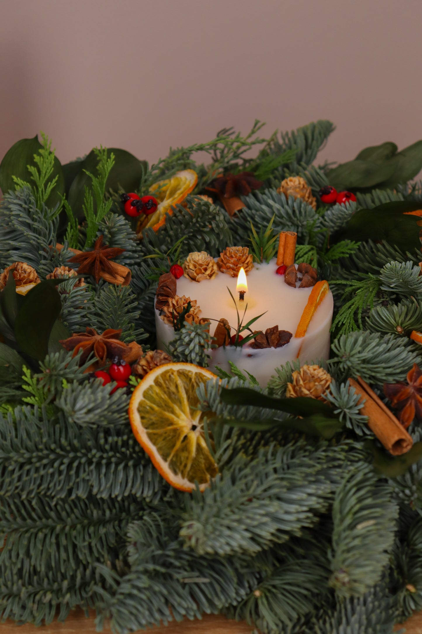 Close-up of botanical Christmas spicy candle—seasonal natural décor
