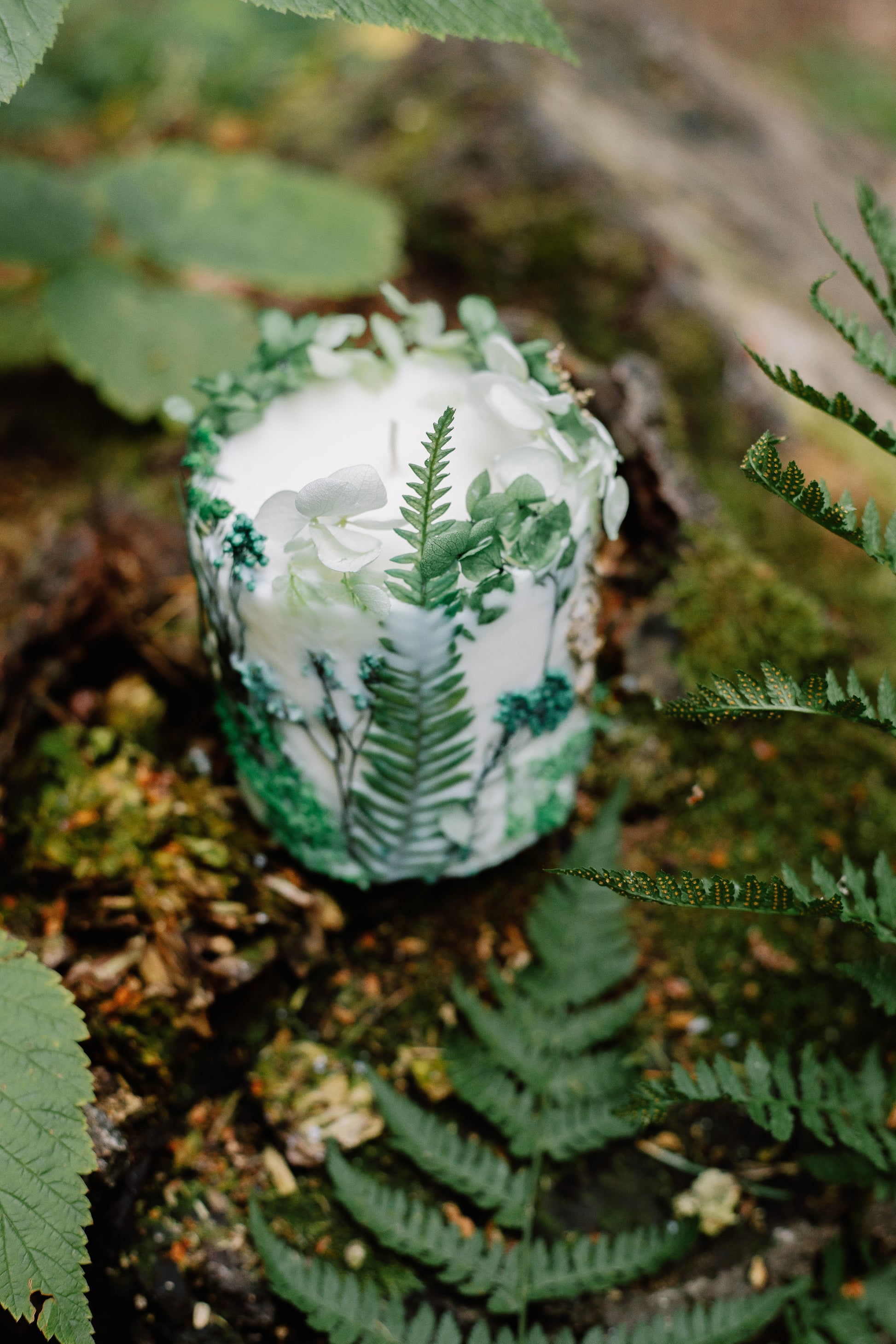 Botanical candle with a forest design on a natural background