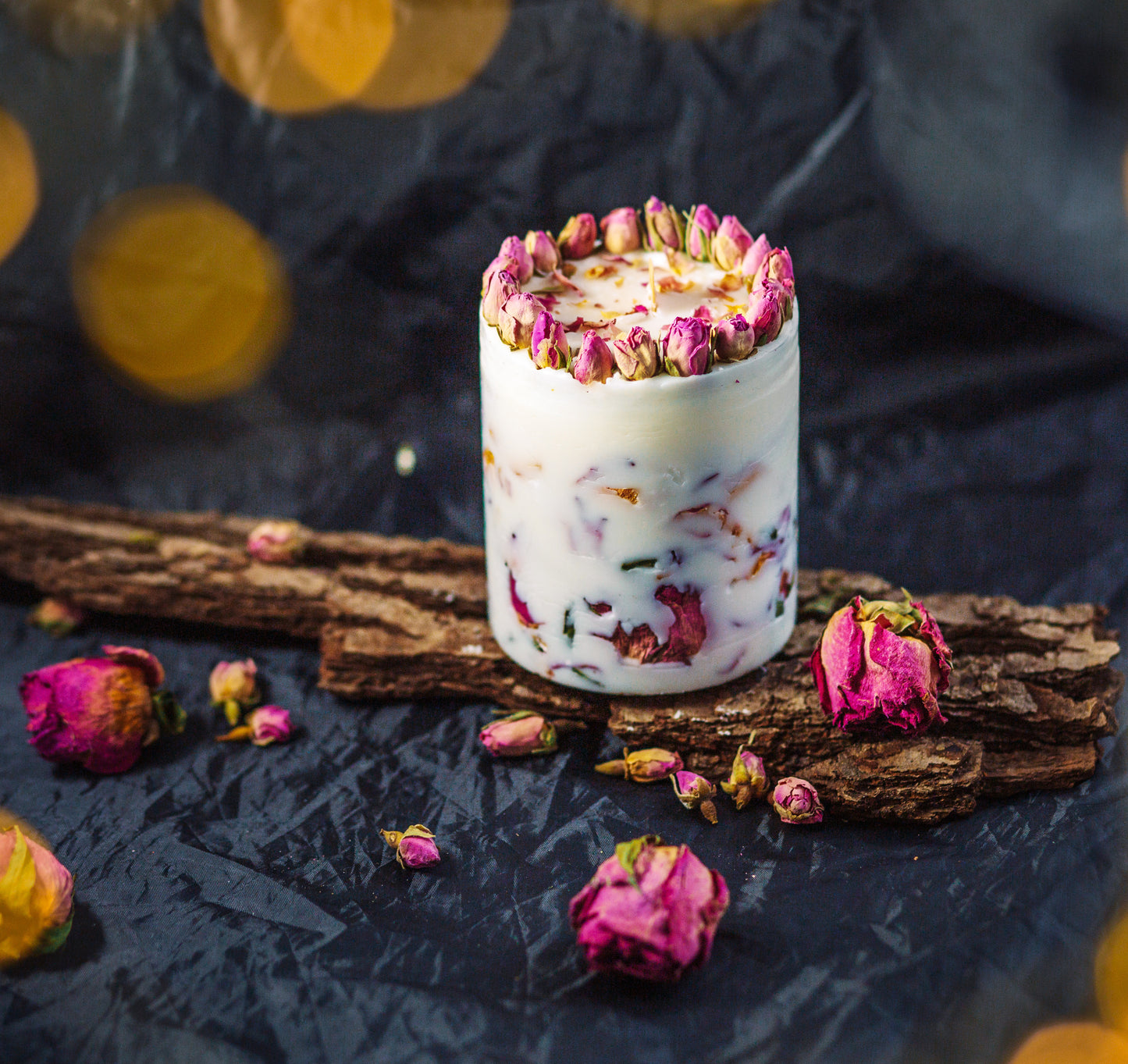 Close-up of rose petals embedded in soy wax botanical candle for home styling