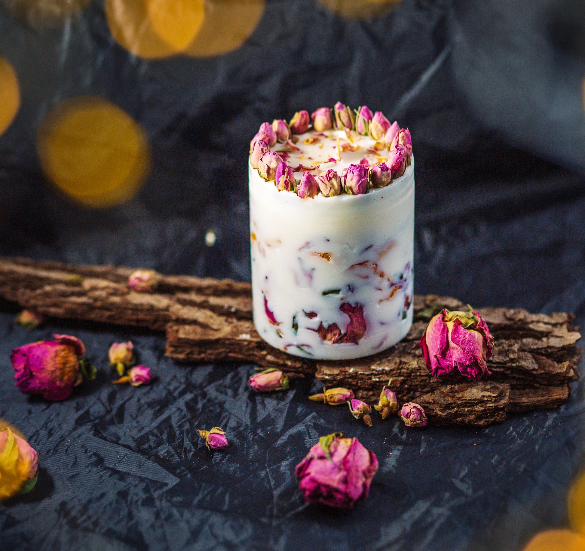 Close-up of rose petals embedded in soy wax botanical candle for home styling