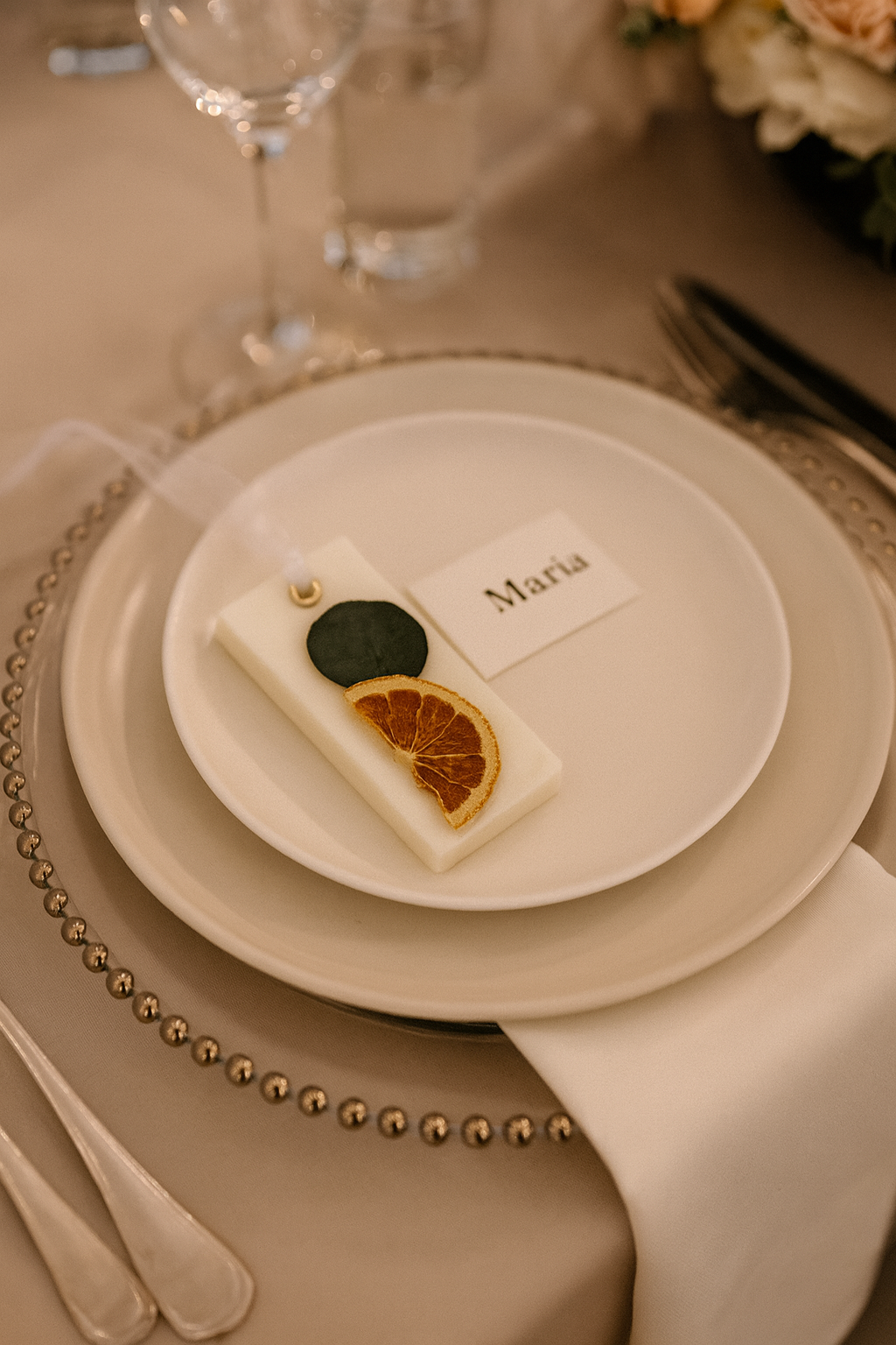 Table setting with a decorative card, party favor and name tag on a plate.